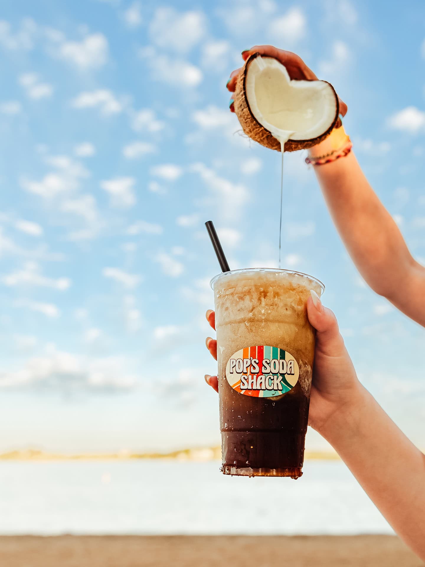Refreshing tropical coconut drink at Pop’s Soda Shack with ocean view.